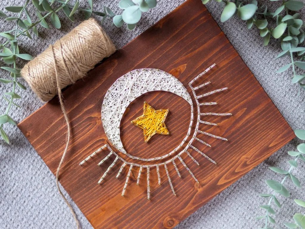 top view of a string art sign with sun moon and stars design